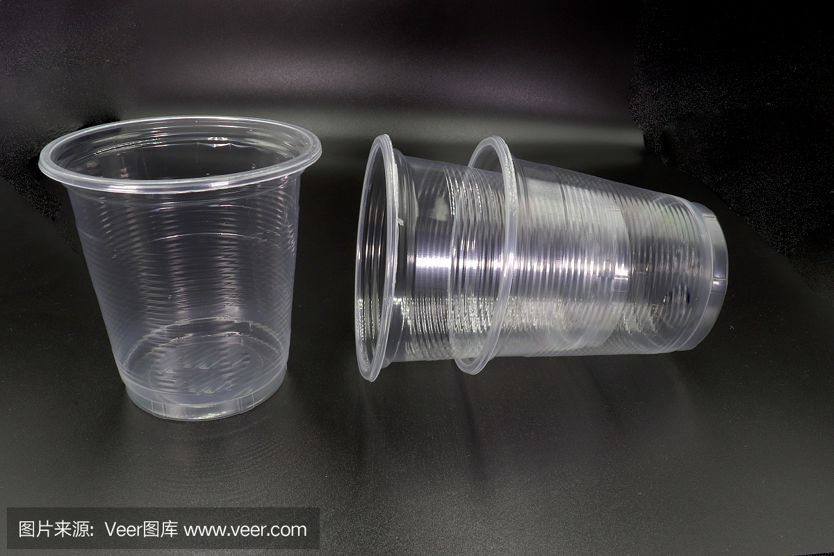 躺著和站著的塑料杯孤立在黑色的背景。高分辨率圖像庫。